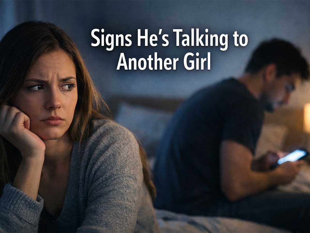 Worried woman sitting on a bed while a man in the background looks at his phone, showing emotional distance in a relationship.