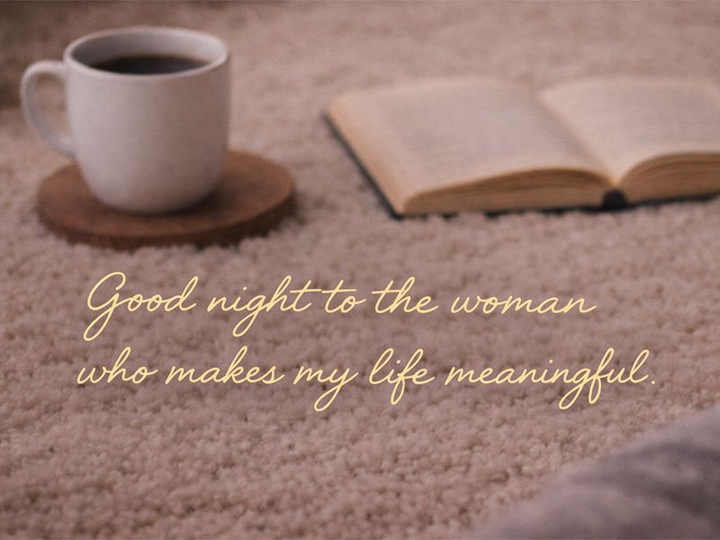 Text reading “Good night to the woman who makes my life meaningful” over a cozy background with a book and a warm cup of coffee.