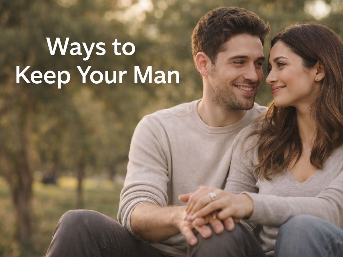 A smiling couple sitting closely together outdoors, looking at each other with affection.
