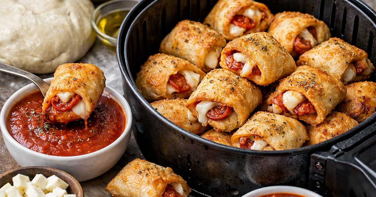 Air fryer pizza rolls stuffed with melted mozzarella and pepperoni, served with marinara sauce
