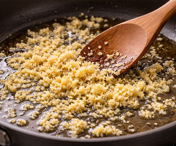 Minced garlic sautéing in oil to build the garlic base