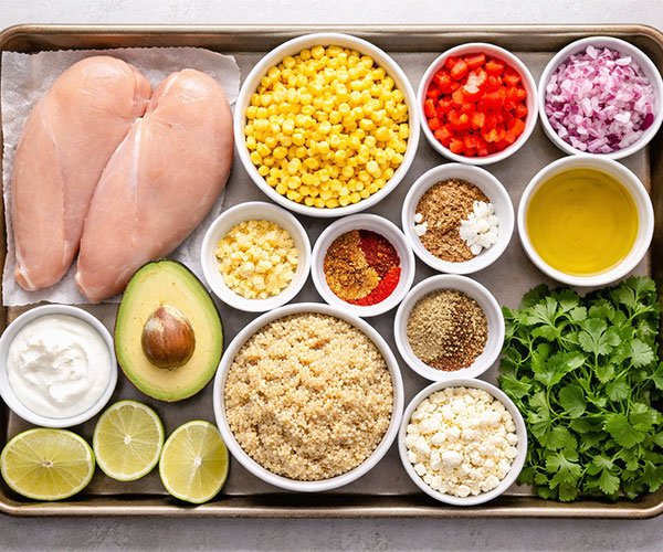 Ingredients for healthy street corn chicken bowls arranged on a tray.