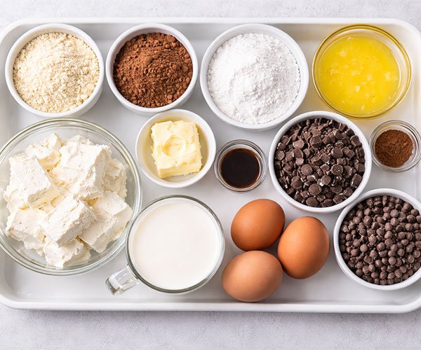 Ingredients for keto Oreo cheesecake bars arranged on tray.